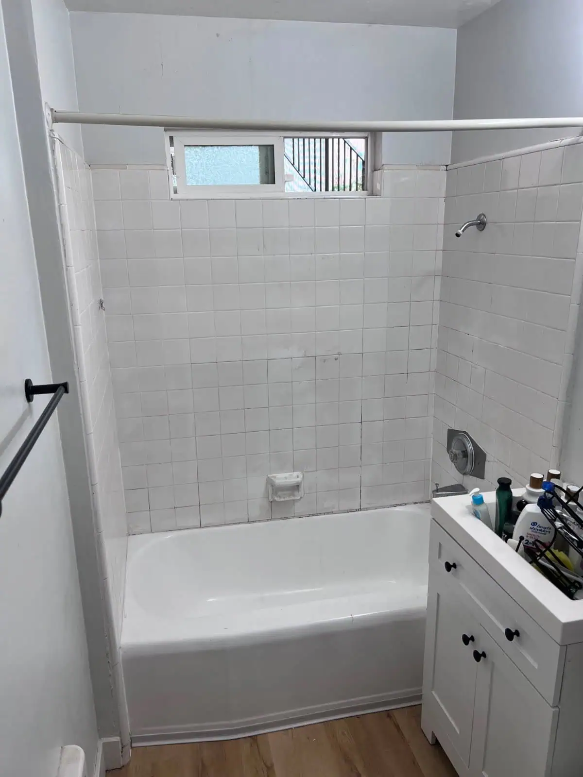 Refinished bathtub with clean white tiles and small window in La Jolla bathroom.